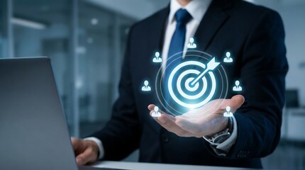 A businessman in a suit projects a glowing target with user icons from his hand while working on a laptop