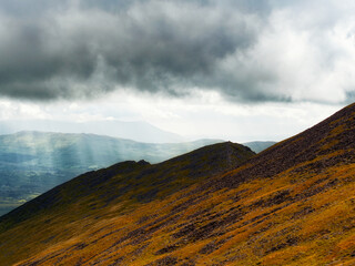An angled view of a mountain edge where light and shadow collide.