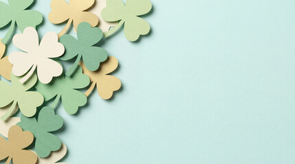 Fototapeta premium Paper shamrock cutouts on mint backdrop. Shamrock border frames wide copy space for st patricks day greeting, shamrock luck theme for spring promo, clean minimal layout, modern card