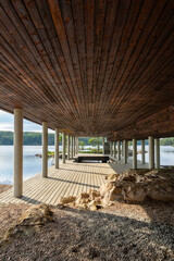 Fototapeta premium Modern Scandinavian Timber Architecture with Covered Deck on Concrete Pilotis by Lake