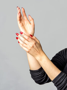 Mains f&eacute;minines aux ongles rouges sur fond gris clair, gestes expressifs, f&eacute;minit&eacute;, &eacute;l&eacute;gance, beaut&eacute;, esth&eacute;tique minimaliste et langage du corps