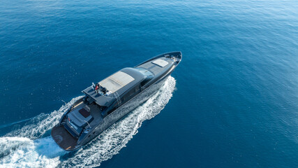 Fototapeta premium Luxury Yacht on Open Waters: A sleek, modern yacht gracefully cuts through the vast expanse of the ocean. Undulating in the endless blue, conveying a sense of freedom and luxury.