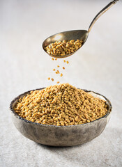 Fenugreek seeds on beige background
