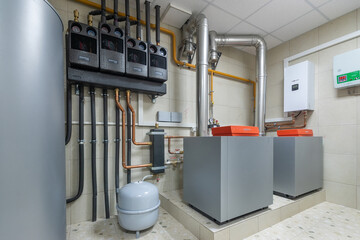 Obraz premium The scene shows a utility room with multiple gas meters, copper pipes, and two heating systems. The space is well organized with essential equipment for heating and utility management