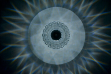 graficzny wzór ze światła lampy, jak źrenica oka, graphic pattern made of lamp light, like the pupil of an eye, Round lamp light reflections, A bright circular light shining in the dark © kateej