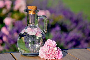 woda r&oacute;żana w szkalnej butelce z korkiem, woda aromatyzowana płatkami r&oacute;ży w butelce, rose water in a glass bottle, water flavored with rose petals in a bottle, Rose water in a glass bottle
