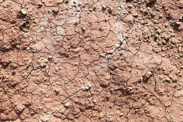 Cracked dry soil surface texture. Brown earth ground closeup. Natural drought background pattern. Rough clay dirt with fissures. Arid land detail for environmental design use background texture soil.