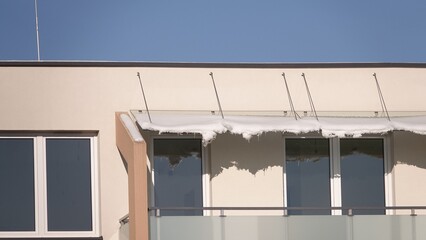 Pokłady śniegu zalegające na szklanym dachu osłaniającym balkon