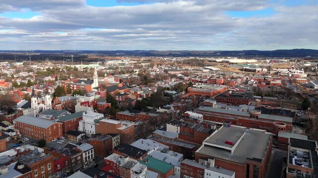 Drone view of a historic downtown area with red brick buildings and hills in Maryland