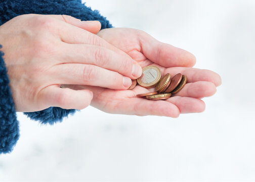 Euro coins in a woman's hands, selective focus.	