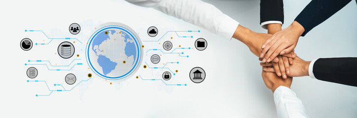 Hands from different individuals pile together around a digital globe, illustrating collaboration and connection in a modern business environment with technology elements. Trope