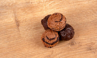 Delicious chocolate truffles with rich cocoa texture placed on a rustic wooden background. Representing sweet dessert, handmade confectionery, gourmet food and indulgent snack concept.