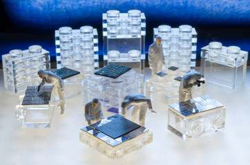 Miniature Cleanroom Workers Assembling Microchip Technology