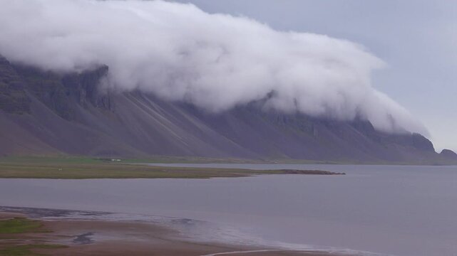 Amazing time lapse shot of remarkable beautiful fjords in Iceland with clouds and fog rolling over the top.