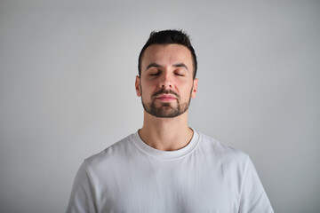 Obraz premium front view of Caucasian man meditating with closed eyes in studio