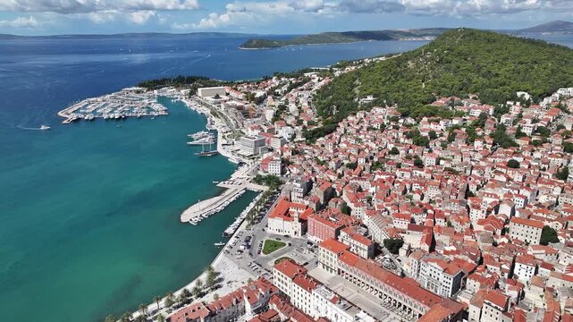 Drone captures Prokurative square, Split west coast, and Marjan hill surrounded by sea and city life.