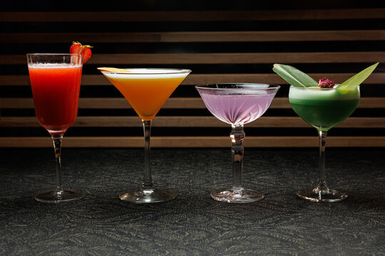 Unique cocktails presented in elegant glassware showcasing vibrant colors and creative garnishes at a trendy bar setting