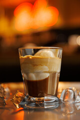 Coffee dessert served with ice and ice cream in a glass at a cafe setting during the evening