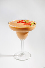 Fruity smoothie served in a clear glass with fresh strawberries and kiwi on top for a fresh drink experience