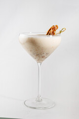 Creamy cocktail garnished with a sweet treat in a glass served at a drink bar or restaurant during a dining experience