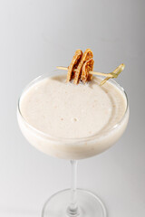 Rich creamy cocktail topped with sweet crispy garnish served in a classic glass