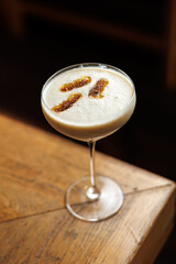 Classic cocktail served in a stylish glass on a wooden table at a cozy bar