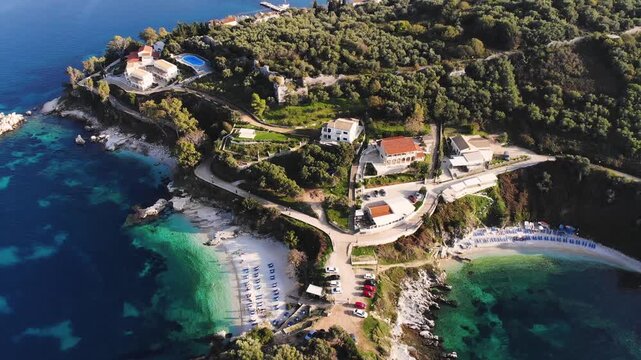 Aerial drone view of Kassiopi, coast sea village in northeast coast of Corfu island, Ionian Islands, Kerkyra, Greece in a summer sunny day, with marina, town, beach and castle, Greek landscape