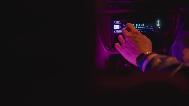 latenight hand tuning radio station, magenta interior glow, fingertip on dial, vintage tuner display, wrist bracelets visible, roadtrip companion searches song, night shift worker switches frequency,