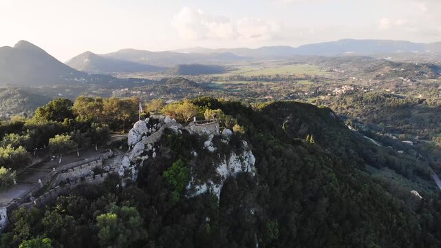 Kaiser's Throne observation deck lookout, Pelekas village, Corfu island, Greece, Kaiser William II summit Observatory panoramic sunny view with mountains, Ionian sea and Kerkyra city in the background