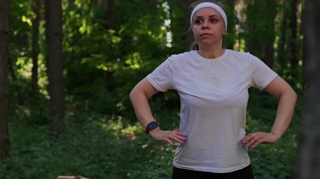 A woman exercises outdoors in a forest setting on a sunny day to improve fitness and health