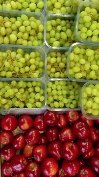 Vertical shot of colorful red apples and green grapes. Details of the Turkish Market at Maybachufer. Berlin, Germany