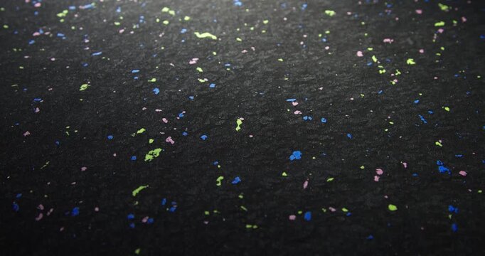 Colourful texture of a material made of recycled plastic. Waste pellets via sintering technique. Bright inclusions of recycled plastic granules. Sustainable material textures.