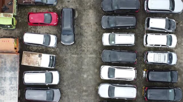 Aerial view of a parking lot lined up with cars for rent