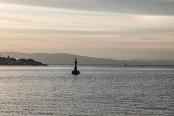 Fototapeta premium Marine Navigation Buoy in a bay in calm sea at sunset