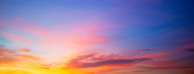 Obraz premium Beautiful sunset and sunrise skies, with purple and orange clouds in various colors,Panoramic view of a breathtaking sunset sky featuring a dramatic blend of purple, pink, and golden orange clouds.