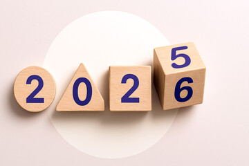 New Year Transition from 2025 to 2026 with Geometric Wooden Blocks – Blue Digits on Circle, Triangle, Square, and Rotating Cube, Symbolic Countdown and Time Progression Concept