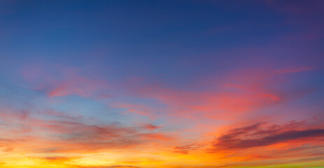 Fototapeta premium Beautiful sunset and sunrise skies, with purple and orange clouds in various colors,Panoramic view of a breathtaking sunset sky featuring a dramatic blend of purple, pink, and golden orange clouds.