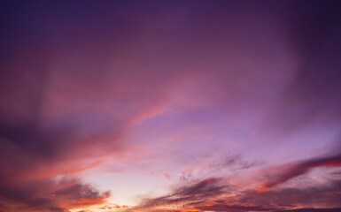 Fototapeta premium Beautiful sunset and sunrise skies, with purple and orange clouds in various colors,Panoramic view of a breathtaking sunset sky featuring a dramatic blend of purple, pink, and golden orange clouds.