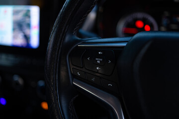 Naklejka premium Close-up of Multifunction Steering Wheel Controls in a Modern Car,A detailed close-up shot of the steering wheel control buttons in a modern vehicle, featuring audio volume, mode selection, 