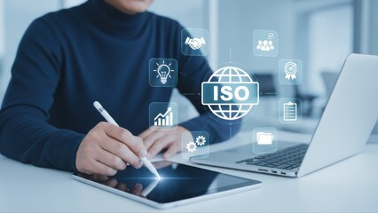 Business professional using a tablet for quality management standards in a modern office environment