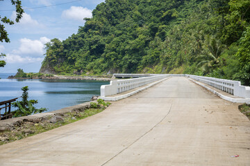 Fototapeta premium wide concrete road along the tropical coastline 