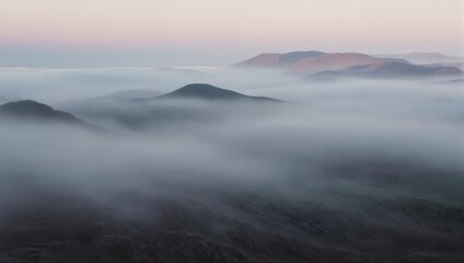 Fototapeta premium Misty Mountains - A Serene Landscape of Peaks Emerging from the Fog.