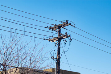 Power lines or communication lines in front of a clear blue sky.