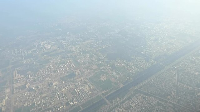 Aerial view of a densely populated urban area extending across the landscape, seen from an aircraft.