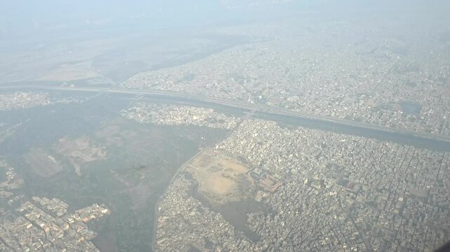 Distant aerial shot showing land patterns and scattered water bodies seen from cruising altitude.