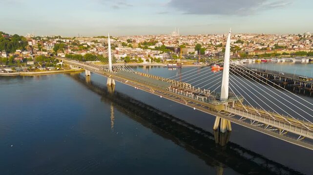 Istanbul, Turkey. Golden Horn Bridge and Halic Metro Station with pedestrian bridge across the Golden Horn illuminated by the morning sun. Aerial View, Point of interest