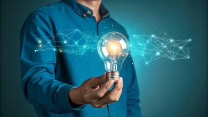Man holding glowing lightbulb with digital network, innovation concept, blue shirt, creative idea