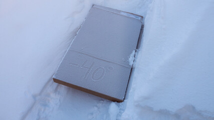 Smartphone frozen in snow, winter cold damage concept