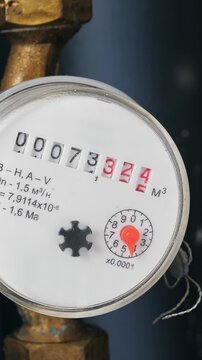 Water meter in box with pipes built into the wall . Water consumption measuring device. Closeup. Vertical footage