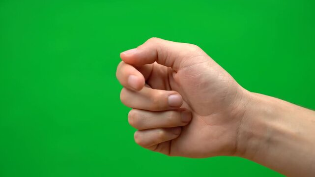 Close-up of a hand with fingers curled against a green screen background